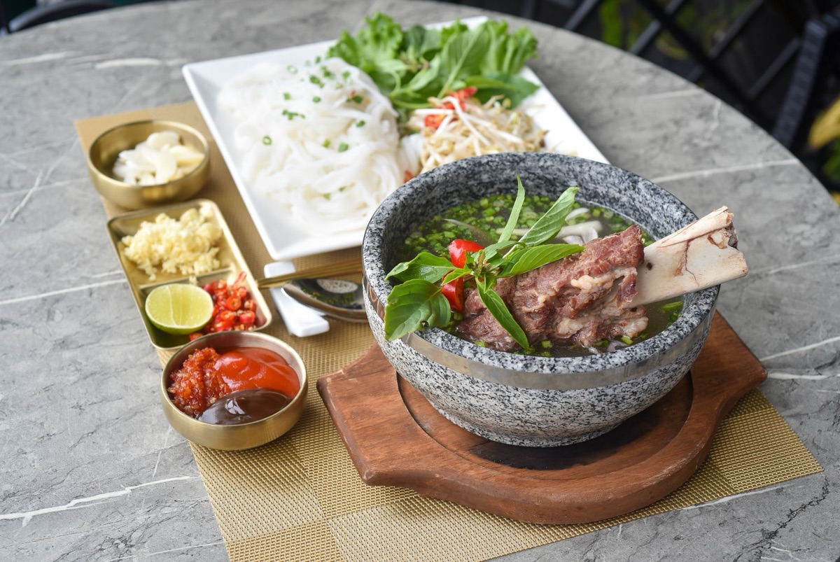 Fideos instantáneos estilo pho vietnamita con rodajas de carne y albahaca.