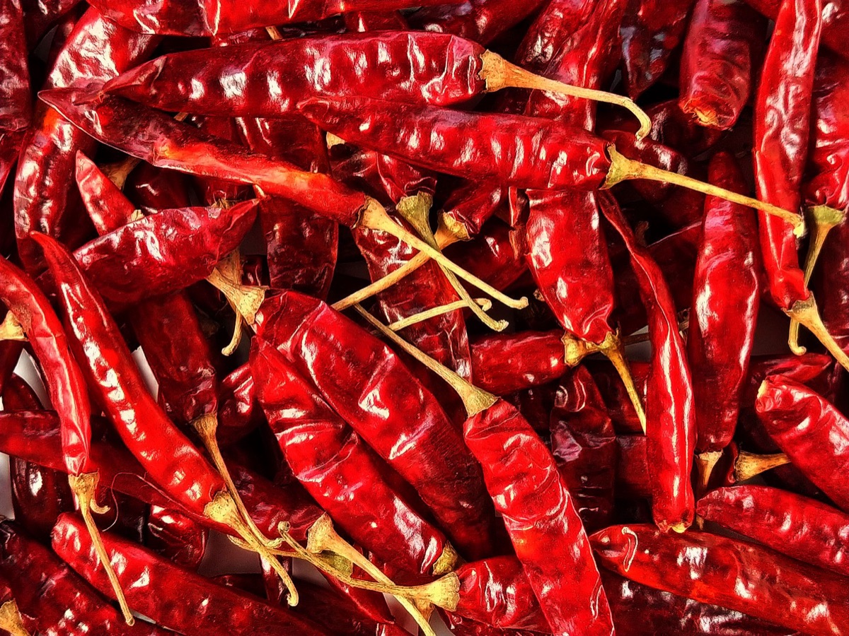 Gedroogde rode chilipepers op een houten achtergrond.