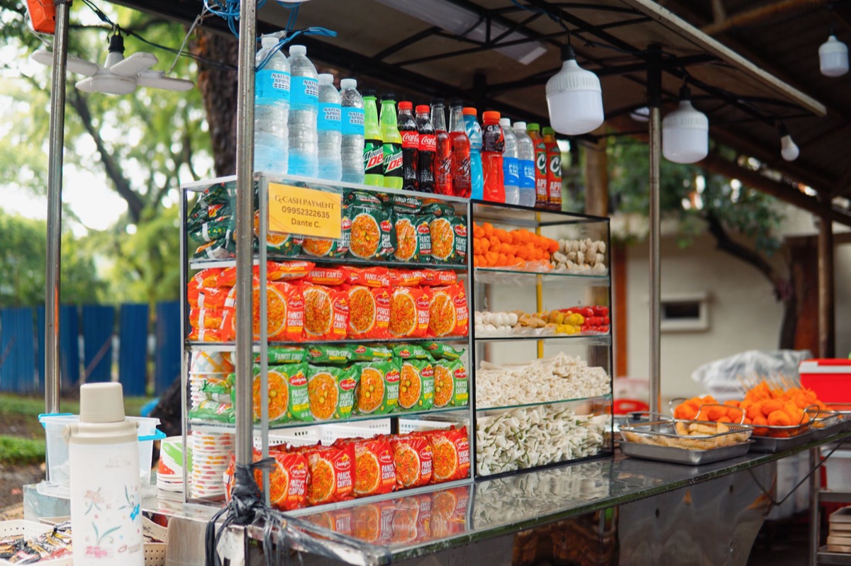 Estantería de tienda de conveniencia llena de diferentes tipos de fideos instantáneos.