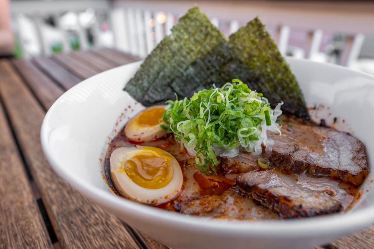 A steaming bowl of premium ramen broth with toppings