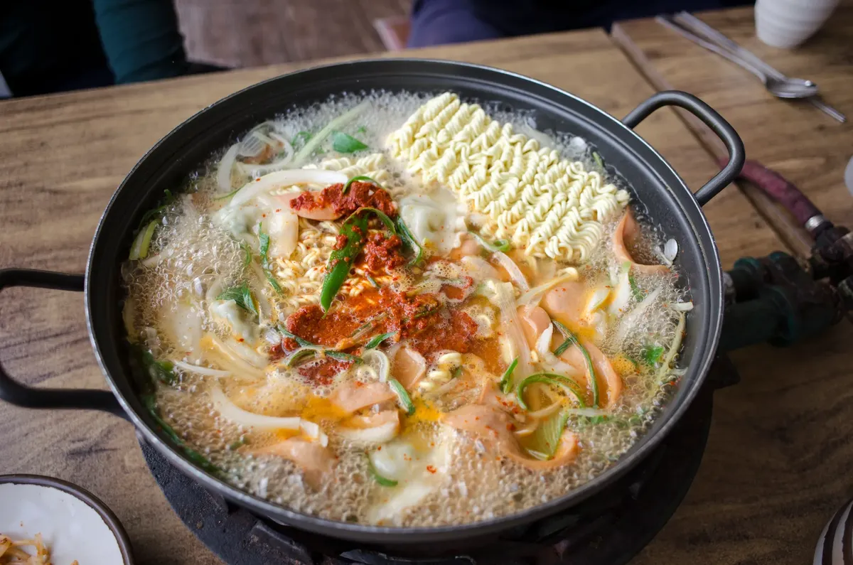 Delicious and spicy Korean ramen soup with vegetables boiling in a pan, capturing the essence of authentic Asian cuisine.