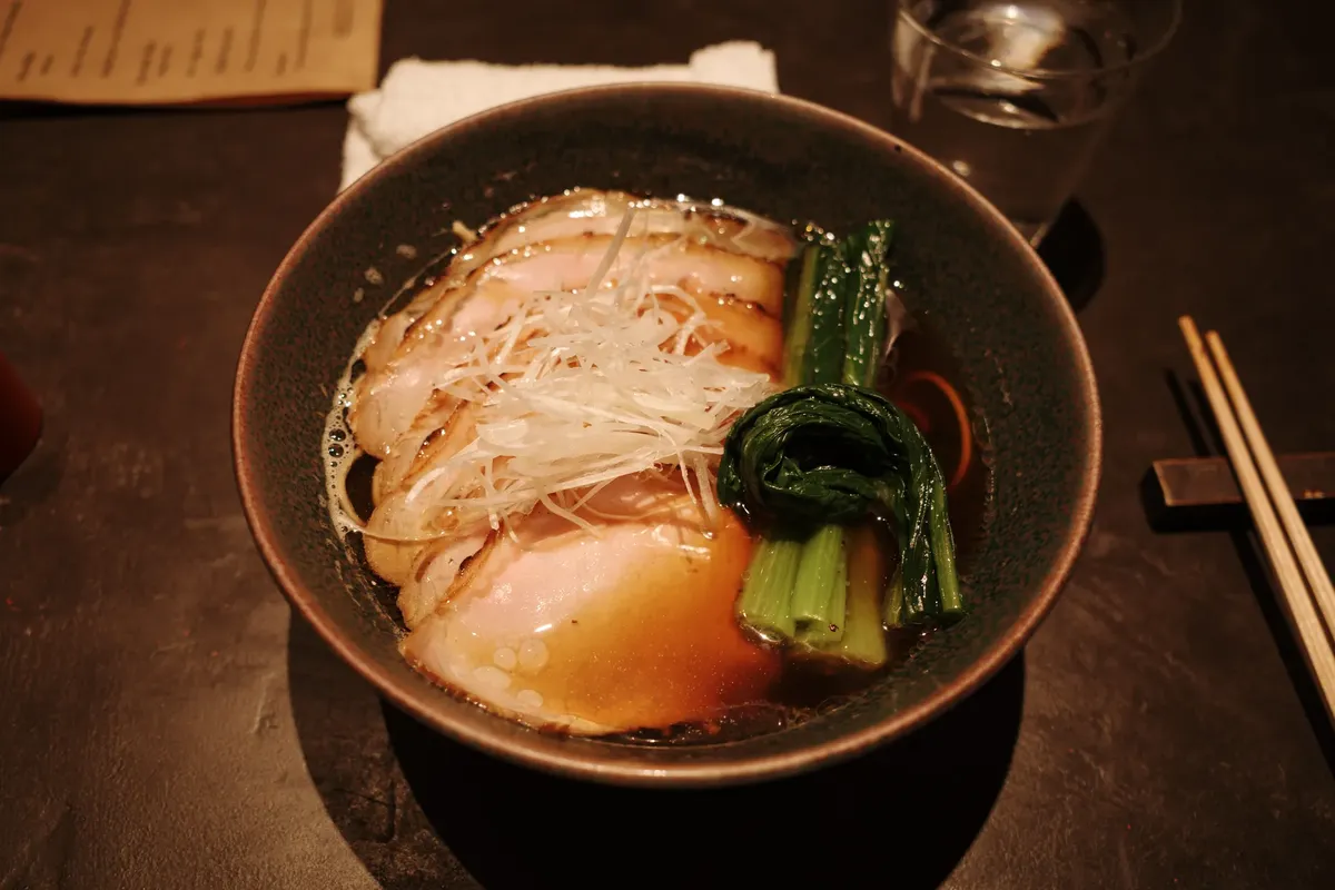 Savor the authentic taste of Japanese ramen with rich broth, pork slices, and fresh greens.